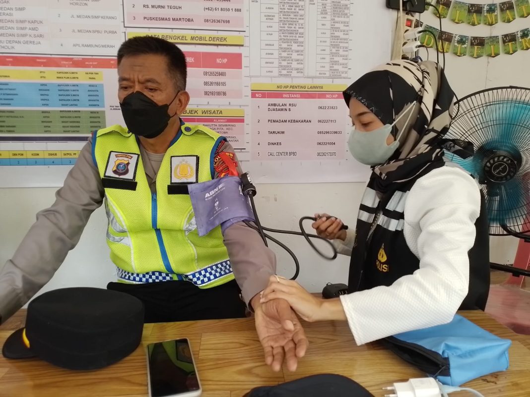 Dokkes Polres Pematangsiantar saat mengecek kesehatan personel yang berjaga di pos pelayanan Ops Ketupat Toba 2024 di Jalan Medan Kota Pematangsiantar, Senin (8/4/2024). (Dok/Humas Polres Pematangsiantar)