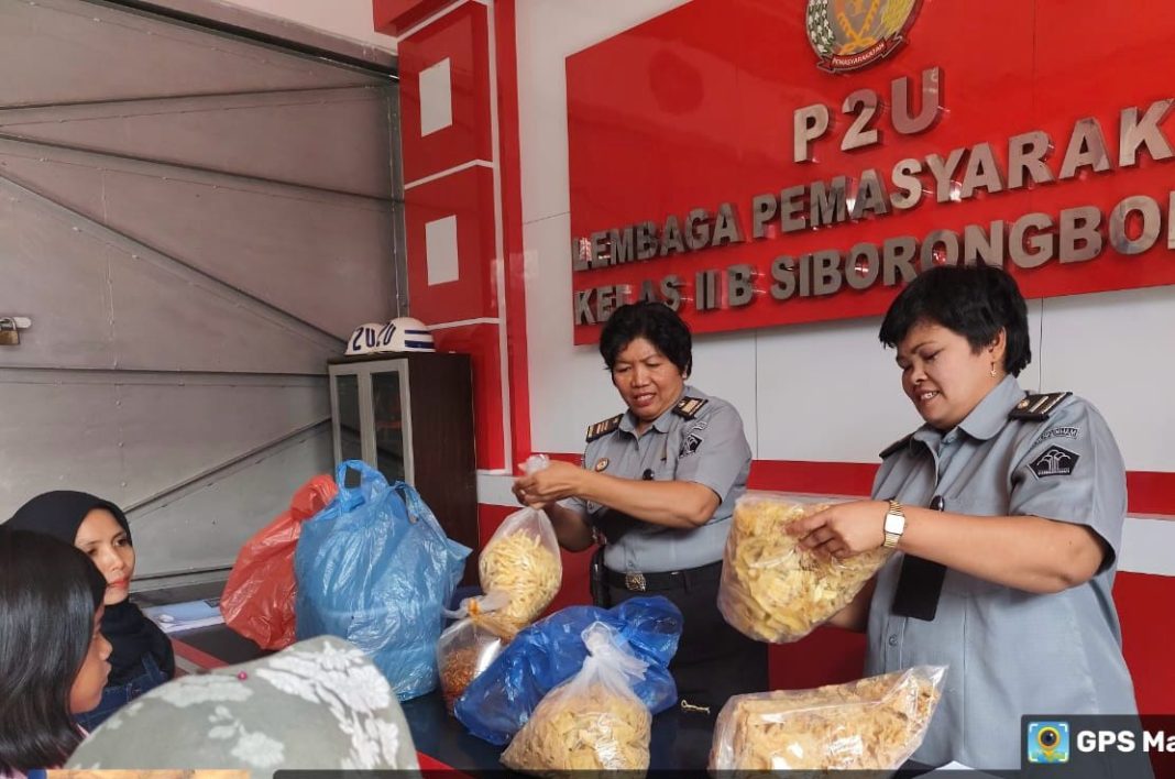 Petugas Lapas Kelas IIB Siborong-borong melakukan pemeriksaan terhadap barang bawaan pengunjung untuk mencegah barang-barang terlarang masuk ke dalam Lapas. (Dok/KPLP Lapas Siborong-borong)