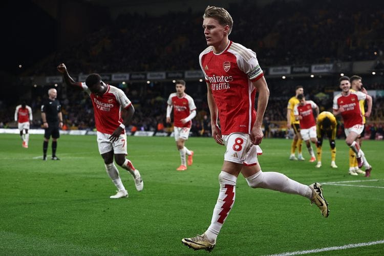 Gelandang Arsenal Martin Odegaard (8/tengah) merayakan gol setelah mencetak gol pada pertandingan Liga Inggris antara Wolverhampton Wanderers vs Arsenal di Stadion Molineux di Wolverhampton, Inggris, Minggu (21/4/2024).