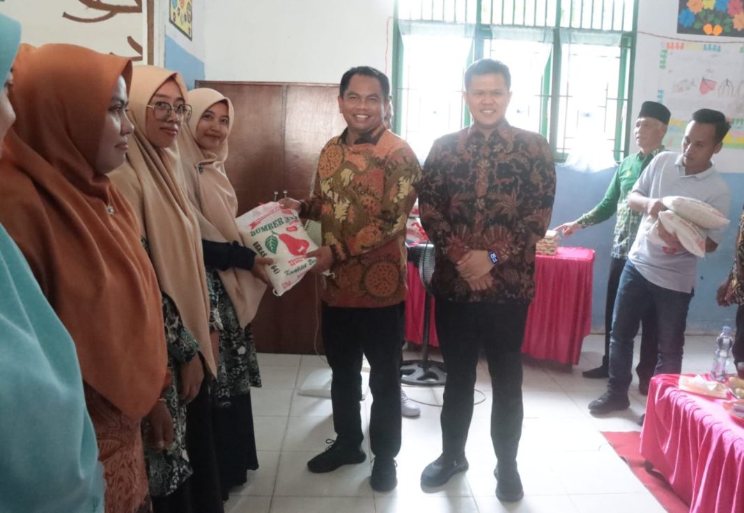 Bupati Sergai H Darma Wijaya didampingi Wakil Bupati Sergai H Adlin Tambunan menyerahkan bantuan beras guru SD Muhammadiyah, Sabtu (20/4/2024). (Dok/Kominfo Sergai)