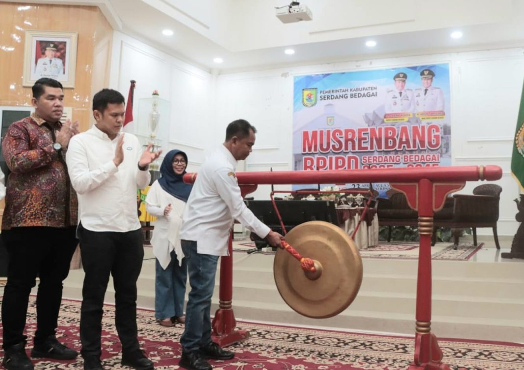 Bupati Sergai H Darma Wijaya didampingi Wakil Bupati Sergai H Adlin Tambunan memukul gong saat membuka Musrenbamg RPJPD Tahun 2025-2045, Selasa (23/4/2024). (Dok/Kominfo Sergai)