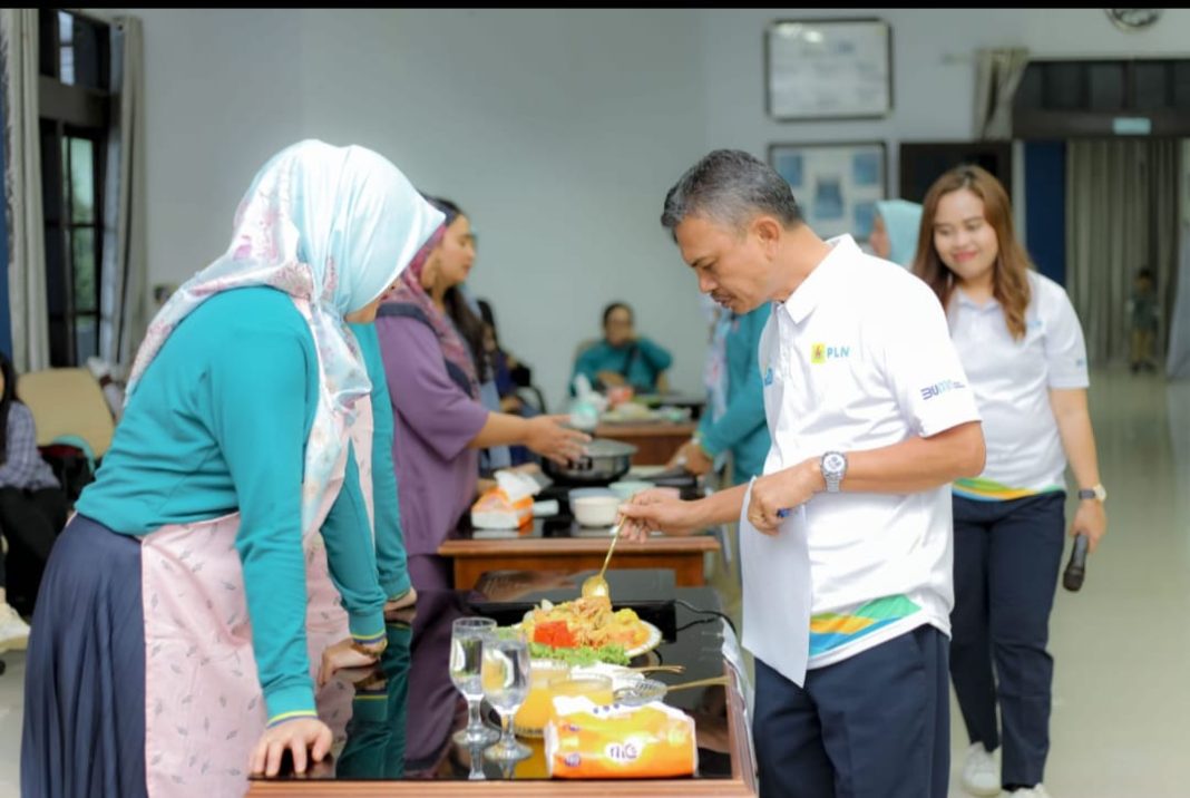 Manager PLN UP3 Bukit Barisan Ramses Hutajulu sedang mencicipi dan menilai hasil masakan peserta lomba memasak menggunakan kompor induksi, Sabtu (1/6/2024). (Dok/PLN)