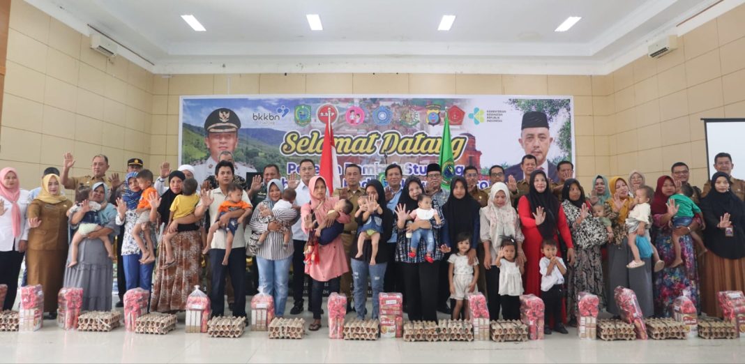 Pj Bupati Paluta Patuan Rahmat Syukur P Hasibuan SSTP MM dan BKKBN serta Tim LGCB-ASR Provinsi Sumut foto bersama dengan keluarga beresiko stunting, Selasa (2/7/2024).