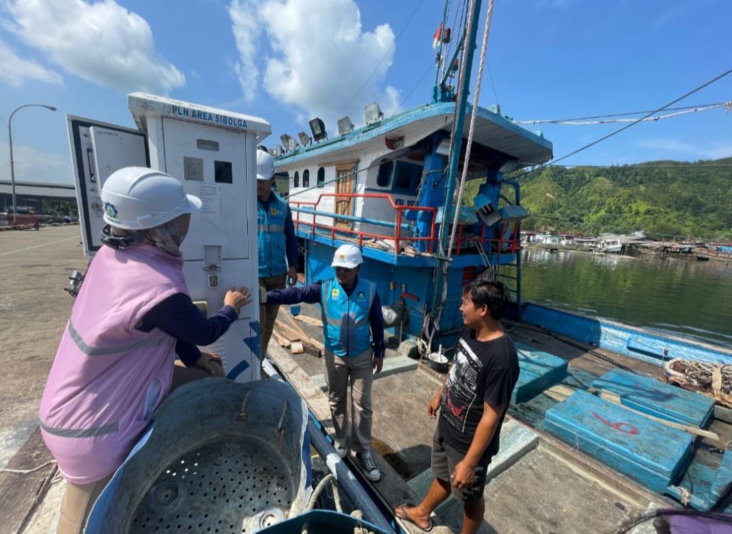 Petugas bersama Srikandi PLN UP3 Sibolga sedang berbincang dengan Hutagalung salah satu pemilik kapal ikan yang sedang menggunakan SPLU saat bersandar di Tempat Pelelangan Ikan (TPI) Kecamatan Sarudik, Kabupaten Tapanuli Tengah, Rabu (3/7).