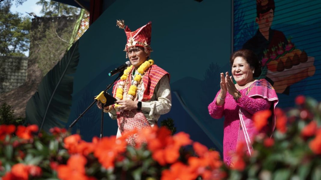 Menparekraf RI Sandiaga Salahuddin Uno mengenakan pakaian adat Karo didampingi Bupati Karo Cory Sebayang saat menyampaikan sambutan di Festival Bunga dan Buah Karo di Taman Mejuah-juah, Berastagi, Jumat (5/7/2024). (Dok/Kominfo Karo)