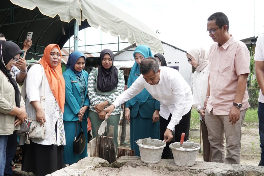 Pj Wali Kota Tebingtinggi Dr Moettaqien Hasrimi saat melakukan peletakan batu pertama, pertanda dimulainya pembangunan RTLH di Jalan Gunung Martimbang, Gang Sosial, Kecamatan Rambutan, Kota Tebingtinggi, Jumat (5/7/2024). (Dok/Kominfo Tebingtinggi)