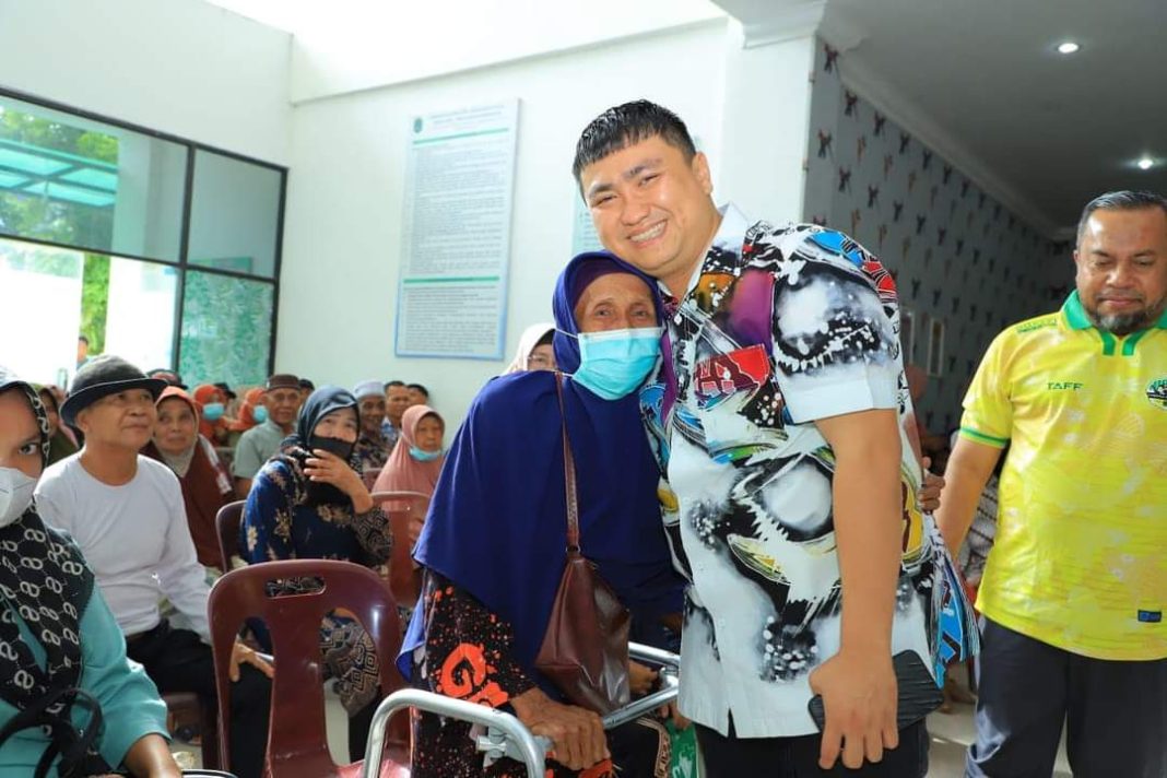 Bupati Labura Hendri Yanto Sitorus merangkul seorang ibu yang menjadi peserta operasi katarak gratis yang dilaksanakan Dinas Kesehatan Labura di RSUD Aekkanopan, Jumat (12/7/2024). (Dok/Kominfo Labura)