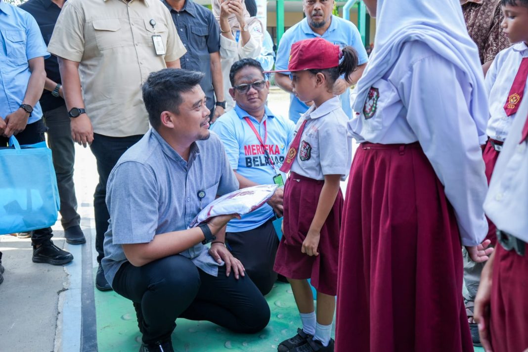 Wali Kota Medan Bobby Nasution didampingi Wakilnya H Aulia Rachman secara simbolis menyerahkan bantuan seragam dan peralatan sekolah kepada siswa kurang mampu di UPT SMPN 1 Medan, Selasa (16/7/2024). (Dok/Kominfo Medan)