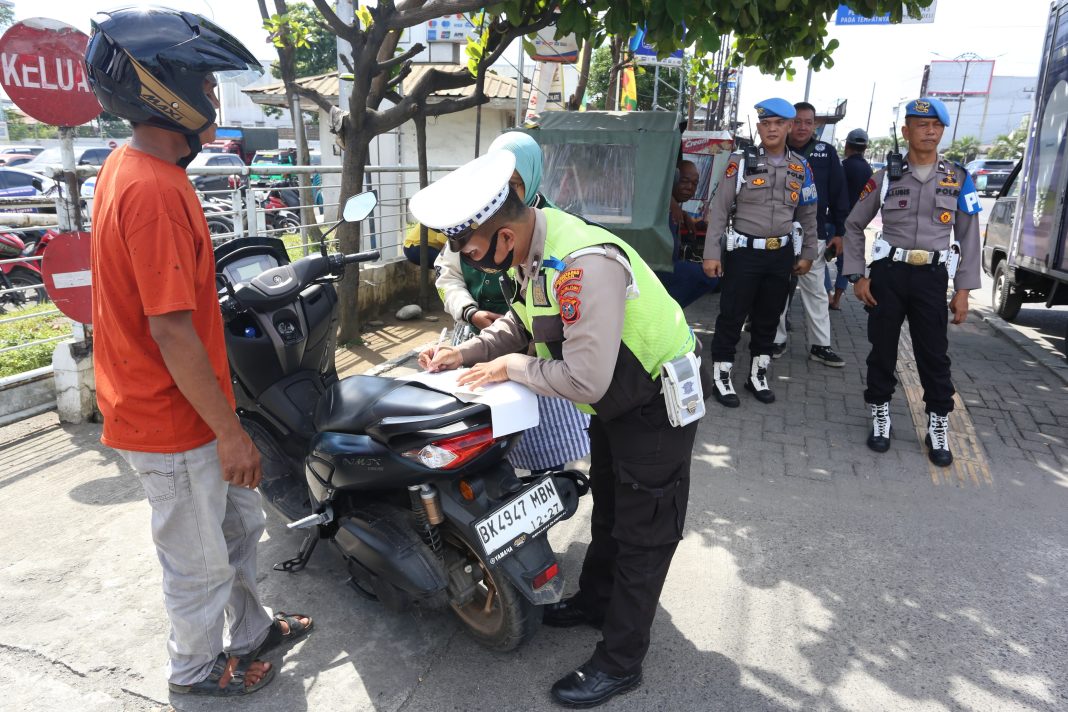 Polisi menilang pengendara yang tidak melengkapi surat-surat kendaraan pada Operasi Patuh Toba 2024. (Dok/Polda Sumut)