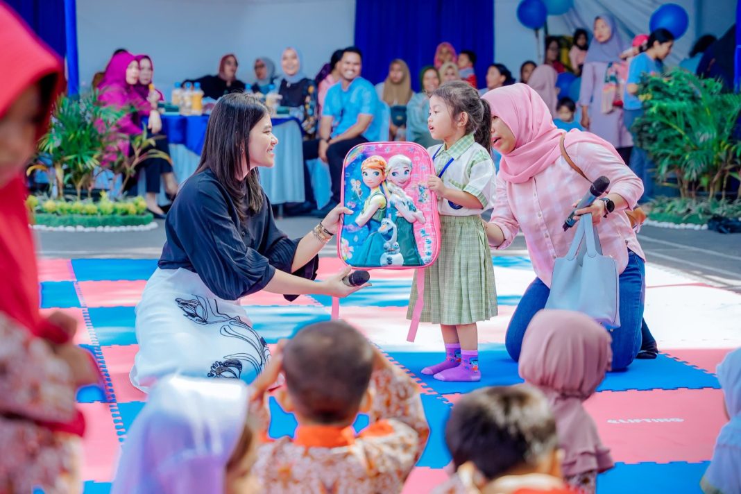 Ketua TP PKK Kota Medan Kahiyang Ayu membagikan hadiah kepada anak-anak pada Peringatan HAN ke-40 tahun 2024 di halaman Kantor Camat Medan Petisah, Jalan Iskandar Muda Medan, Selasa (23/7/2024). (Dok/Kominfo Medan)