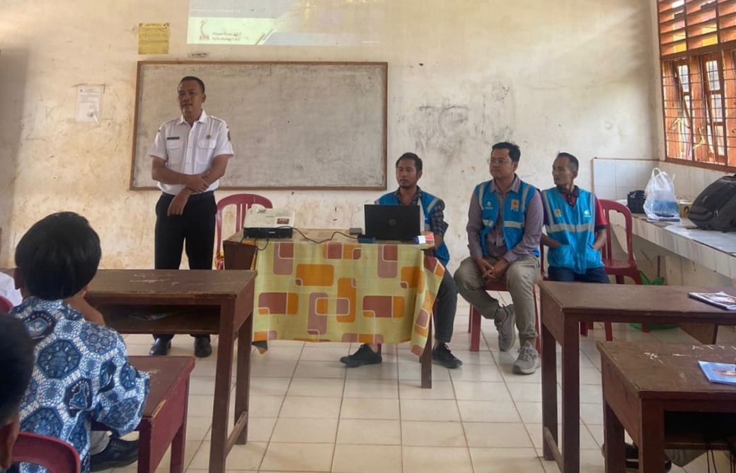 Guru SMKN 1 Portibi Ahmad Hendri Siregar (kiri) memberikan sambutan dalam kegiatan sosialisasi manfaat dan bahaya listrik bagi pelajar, Rabu (24/7/2024).