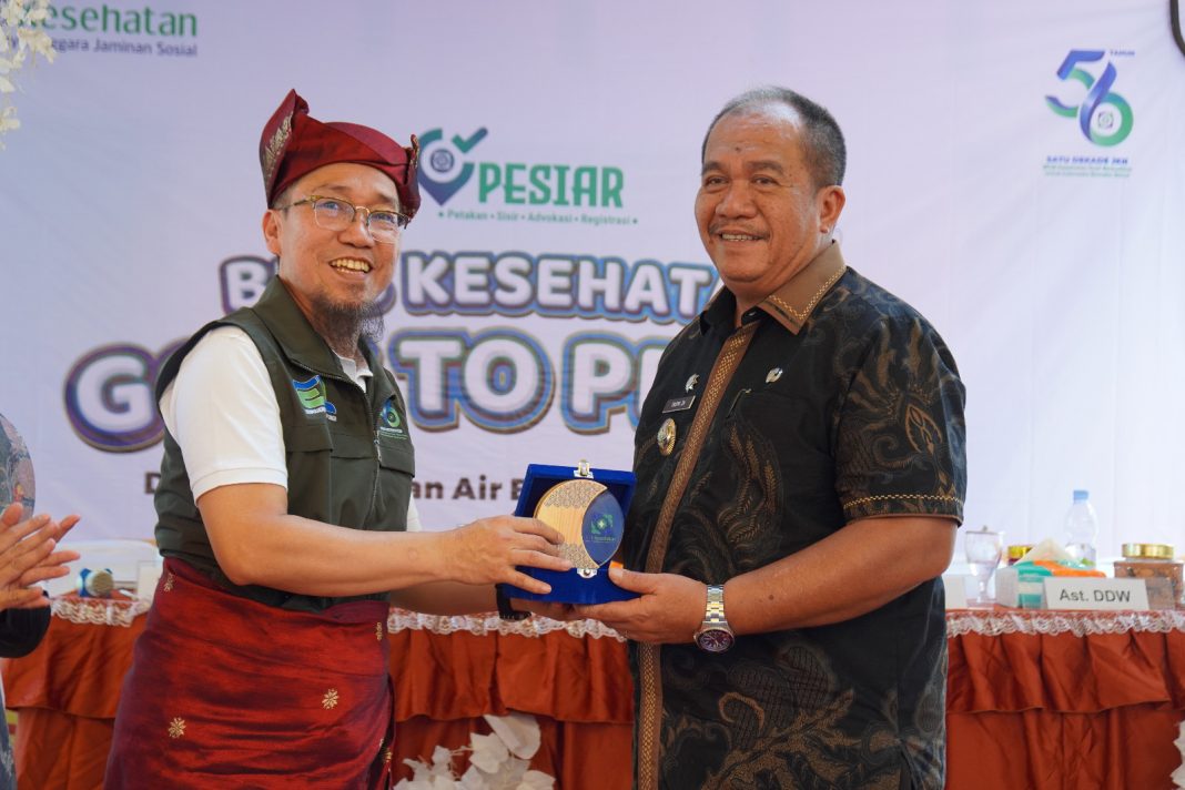 Dewas BPJS Kesehatan Indra Yana memberikan plakat kepada Wakil Bupati Kabupaten Asahan Taufik Zainal Abidin Siregar, Kamis (25/7/2024). (Dok/BPJS Kesehatan Sumut)