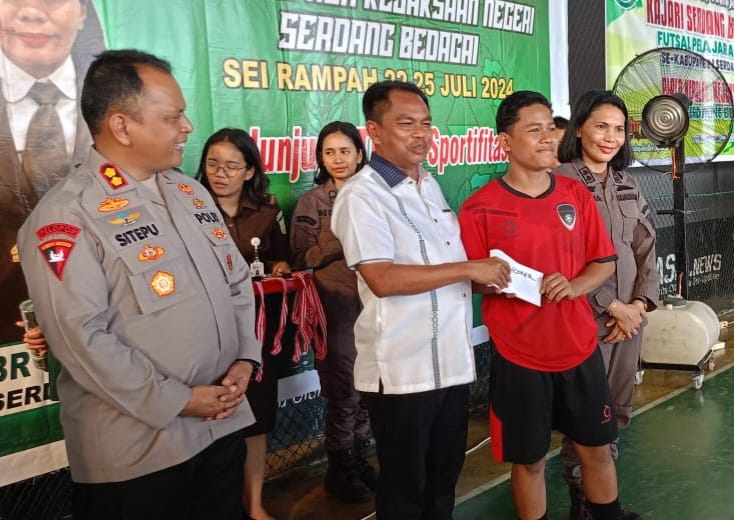 Bupati Sergai Darma Wijaya bersama Kajari Sergai Rufina br Ginting dan Kapolres AKBP Jhon Hery Rakutta Sitepu menyerahkan dana pembinaan kepada Fahriza, top skor turnamen futsal Kajari Sergai Cup tingkat SMP, Kamis (25/7/2024).