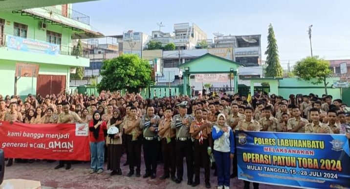 Kanit Kamsel Satlantas Polres Labuhanbatu Ipda Beny AZ berfoto bersama ratusan pelajar SMKN 1 Rantau Utara seusai penyuluhan keamanan, keselamatan, dan kelancaran berlalu lintas di sekolah tersebut, Jalan Ahmad Yani Rantauprapat, Jumat (26/7/2024). (Dok/Humas)