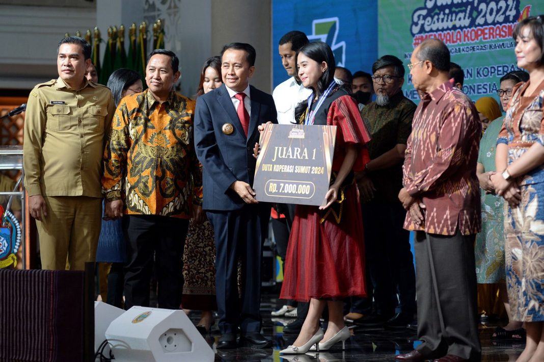 Pj Gubernur Sumut Agus Fatoni menyerahkan hadiah juara 1 Duta Koperasi Sumut pada acara Harkop Festival 2024 di Aula RIS Kantor Gubernur Sumut, Senin (22/7/2024). (Dok/Diskop Sumut)