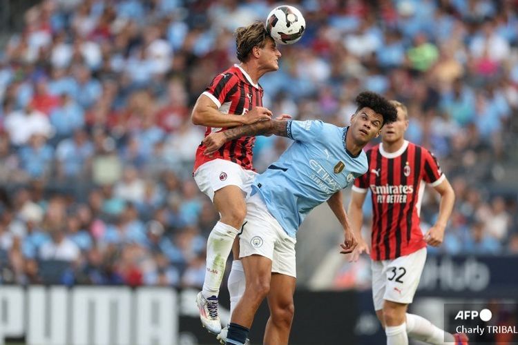 Penyerang AC Milan asal Italia, Lorenzo Colombo (L) berebut bola dengan gelandang Manchester City asal Inggris, Nico O'Reilly (75), dalam pertandingan persahabatan antara Manchester City dan AC Milan di Stadion Yankee, New York, Minggu (28/7/2024) pagi WIB.