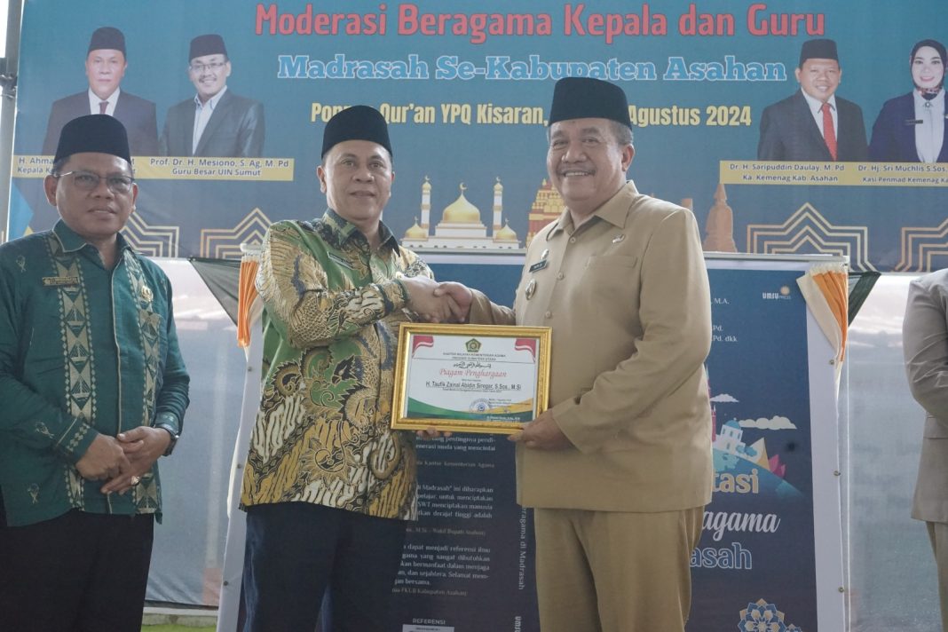 Kepala Kantor Wilayah Kementerian Agama Provinsi Sumut H Ahmad Qosbi SAg MM menyerahkan piagam penghargaan sebagai Tokoh Moderasi Beragama Sumut tahun 2024 kepada Wakil Bupati Asahan Taufik Zainal Abidin SSos MSi di aula Ponpes Qur'an YPQ Kisaran, Kamis (1/8/2024). (Dok/Kominfo Asahan)