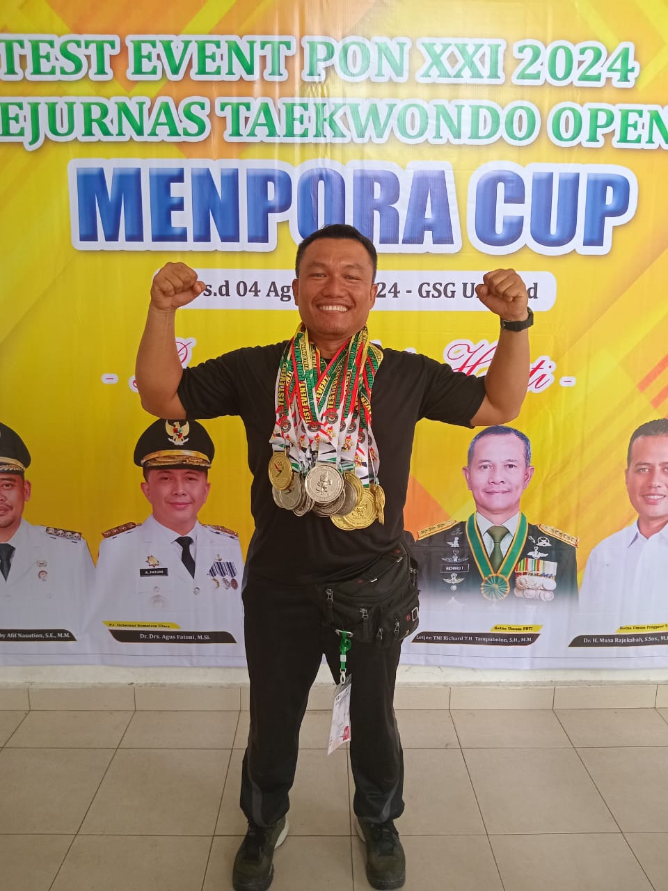 Pelatih Roni Ginting mengalungkan medali kepada para atlet setelah kejuaraan nasional Taekwondo Menpora Cup di Gedung Serbaguna Unimed, 1-4 Agustus 2024. (Dok/Humas)