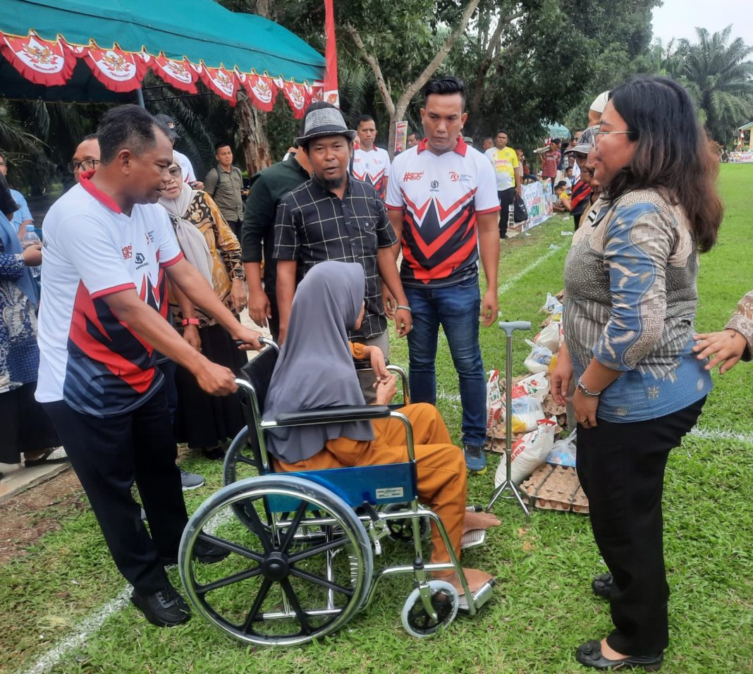 Bupati Sergai H Darma Wijaya menyerahkan kursi roda kepada warga penderita stroke saat membuka turnamen sepakbola Forkopinda Cup U-23, Kamis (15/8/2024).