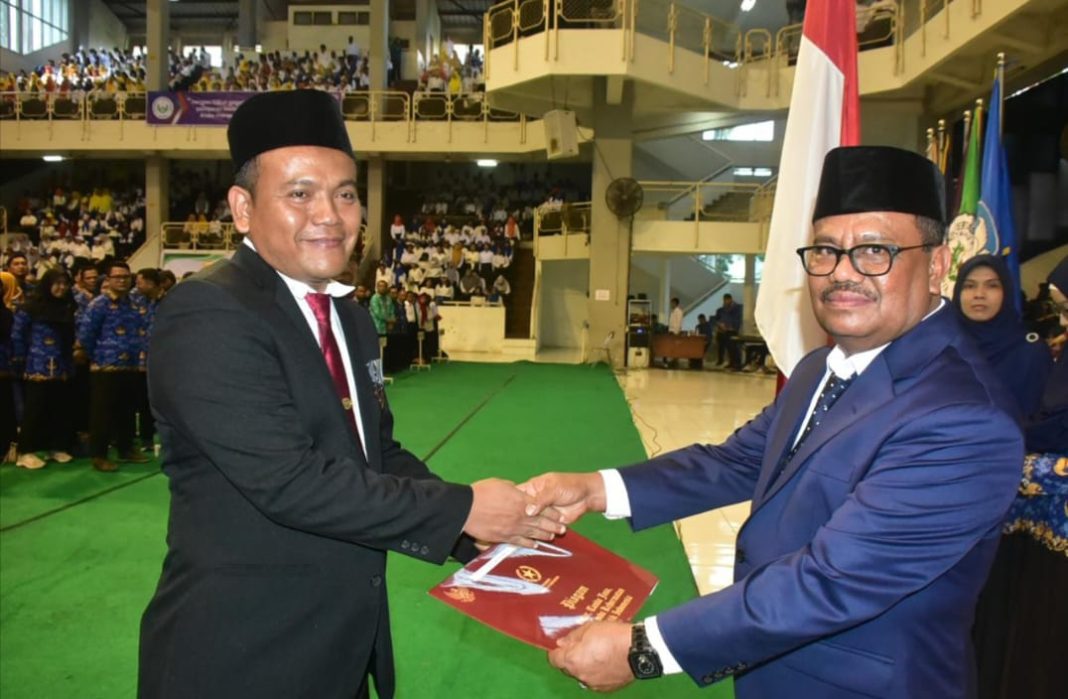 Rektor Unimed Prof Baharuddin menyerahkan penghargaan Satya Lencana Karya Satya ke- X dari Presiden Jokowi kepada Dr Surif.