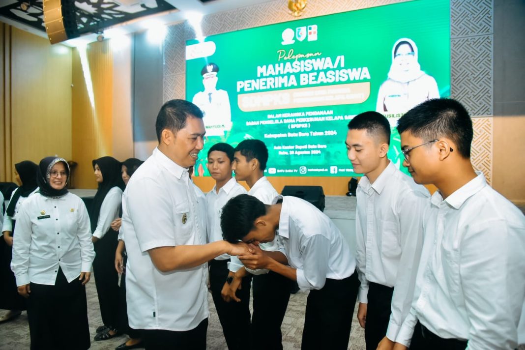 Pj Bupati Batubara Heri Wahyudi didampingi Kadis Pertanian dan Perkebunan Sulistiawati menyalami mahasiswa penerima beasiswa dari BPDPKS pada pelepasan di Aula Kantor Bupati Batubara, Rabu (28/8/2024). (Dok/Kominfo Batubara)