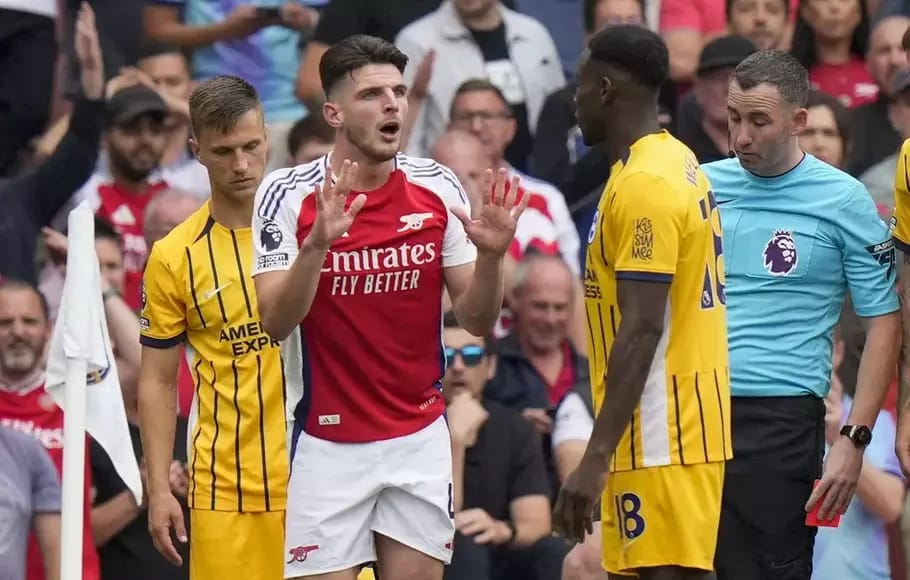 Gelandang Arsenal Declan Rice (merah) bereaksi setelah mendapat kartu kuning kedua sehingga harus meninggalkan lapangan saat bertemu Brighton and Hove Albion, Sabtu (31/8/2024).