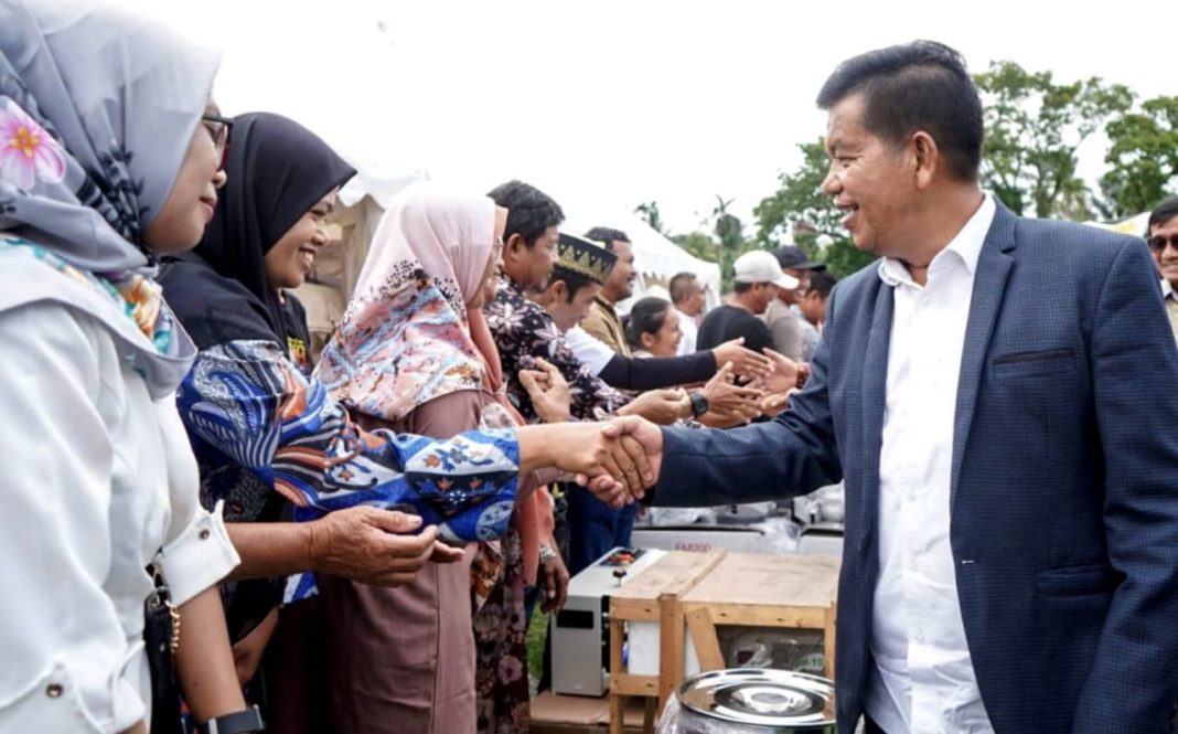 Bupati Simalungun Radiapoh Hasiholan Sinaga menyalami masyarakat saat peringatan HUT ke-77 Koperasi di Paneitongah, Sabtu (31/8/2024). (Dok/Kominfo Simalungun)