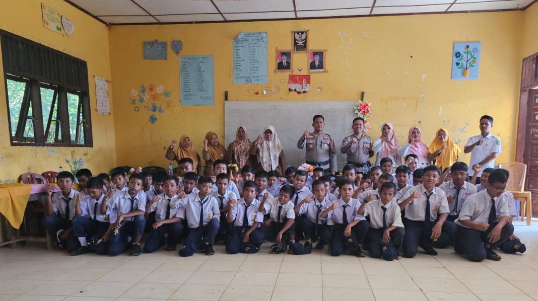 Kapolsek Barumun Tengah Iptu Elimawan SH MH, Kepsek Salbia Hasibuan beserta para dewan guru, komite dan pelajar di SMPN 1 Barumun Barat foto bersama usai penyuluhan bahaya narkoba, Selasa (3/9/2024). (Dok/Kapolsek Barteng)