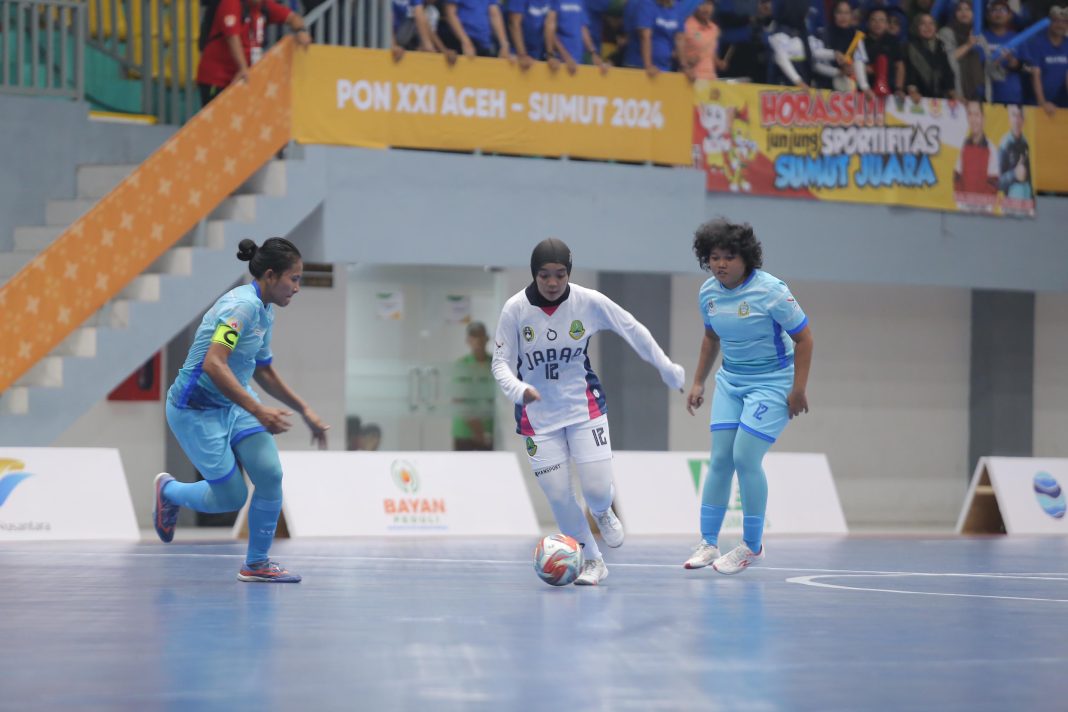 Kapten Tim Futsal Putri Sumut Junita Tampubolon (kiri) berusaha merebut bola dari kaki pemain Jabar pada laga semi final PON XXI di GOR Dispora Sumut, Sabtu (7/9/2024). (Dok/IDN)