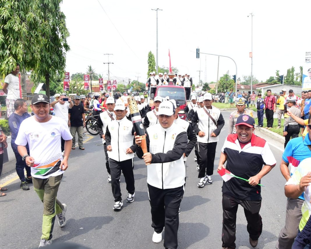 Pj Sekda Deliserdang Citra E Capah dan rombongan membawa kirap api PON XX usai diterima di Lubukpakam, Minggu (8/9/2024). (Dok/Kominfo Deliserdang)
