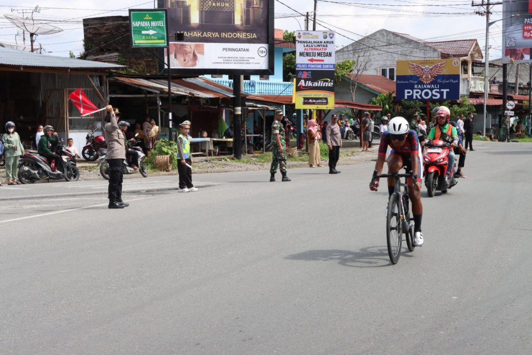 Personel Polres Pematangsiantar saat mengamankan lintasan balapan sepeda putra putri dari wilayah Kota Pematangsiantar, Jumat (13/9/2024). (Dok/Polres Pematangsiantar)