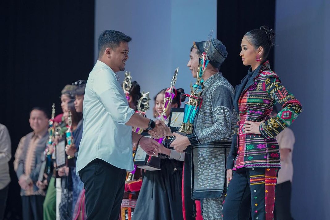 Wali Kota Bobby Nasution menyerahkan piala kepada para pemenang fashion show wastra dan kriya dari para perancang yang dibawakan puluhan model dalam ajang MFF, Hotel Santika Dyandra, Medan. (Foto Dok/Humas)