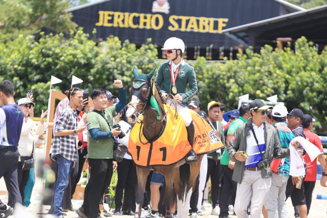 Dinov Zayan Fatih menunggangi kuda Leneke saat meraih medali emas di nomor Lompat Rintangan Individu Kelas 110 cm PON XXI, Jericho Stable, Kabupaten Sergai, Rabu (18/9/2024). (Dok/PB PON XXI Sumut).