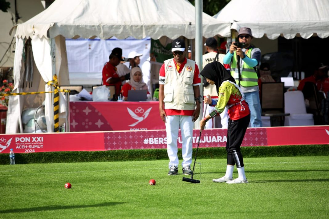 Atlet Gateball Sumbar Chelsi Putri Velysa (kanan) melakukan touch (pukulan sentuhan) saat melawan Atlet Gateball Sumut Restika Ndruru pada Tunggal Wanita di Lapangan Pergatsi, Medan, Kamis (19/9/2024) (Dok/PB PON XXI Sumut).