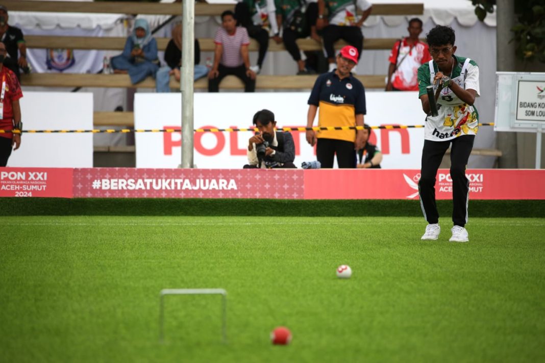 Atlet Gateball Sumut Ahmad Yapist memukul bola ke arah gawang saat melawan Tim Gateball NTT pada Semifinal Beregu Pria di Lapangan Pergatsi, Medan, Rabu (18/9/2024). (Dok/PB PON XXI Sumut)