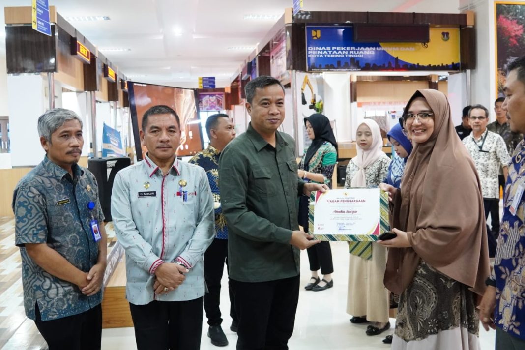 Pj Wali Kota Tebingtinggi Dr Moettaqien Hasrami didampingi Plt Sekda H Kamlan Muryid memberikan penghargaan kepada pegawai kepada pegawai MPP di MPP, Kamis (26/9/2024). (Dok/Kominfo Tebingtinggi)