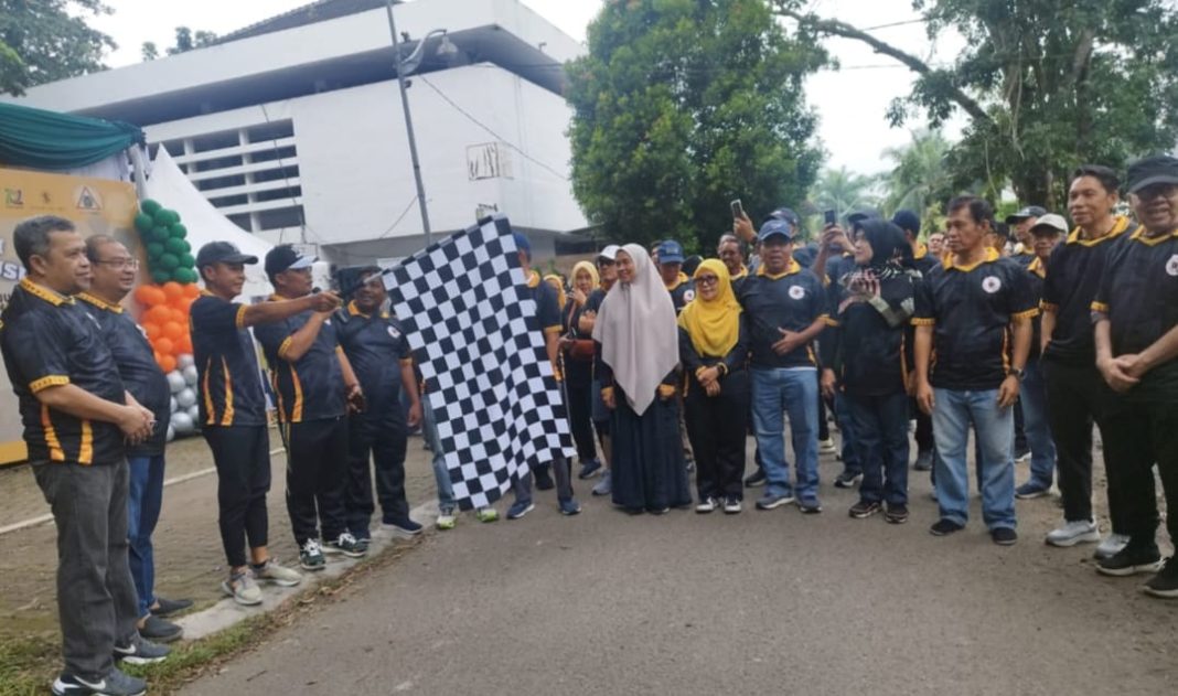 Rektor USU Prof Muryanto Amin mengangkat bendera start dalam kegiatan FUN Walk mengelilingi USU pada Puncak Lustrum XIII di kampus Teknik Sipil Fakultas Teknik USU, Sabtu (28/9/2024). (Dok/Panitia)