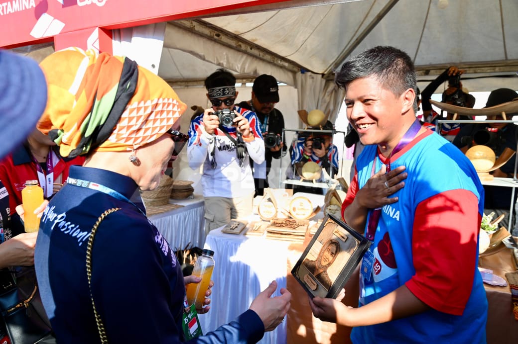 Salah satu UMKM Pertamina memberikan kerajinan kayu berupa wajah kepada Direktur Utama Pertamina Nicke Widyawati saat mengunjungi booth booth UMKM Pertamina yang berada di Pertamina Energizing You Festival yang merupakan bagian acara Pertamina Grand Prix Of Indonesia 2024 di Pertamina Mandalika International Circuit, Lombok, Sabtu (28/9/2024). (Dok/Pertamina)