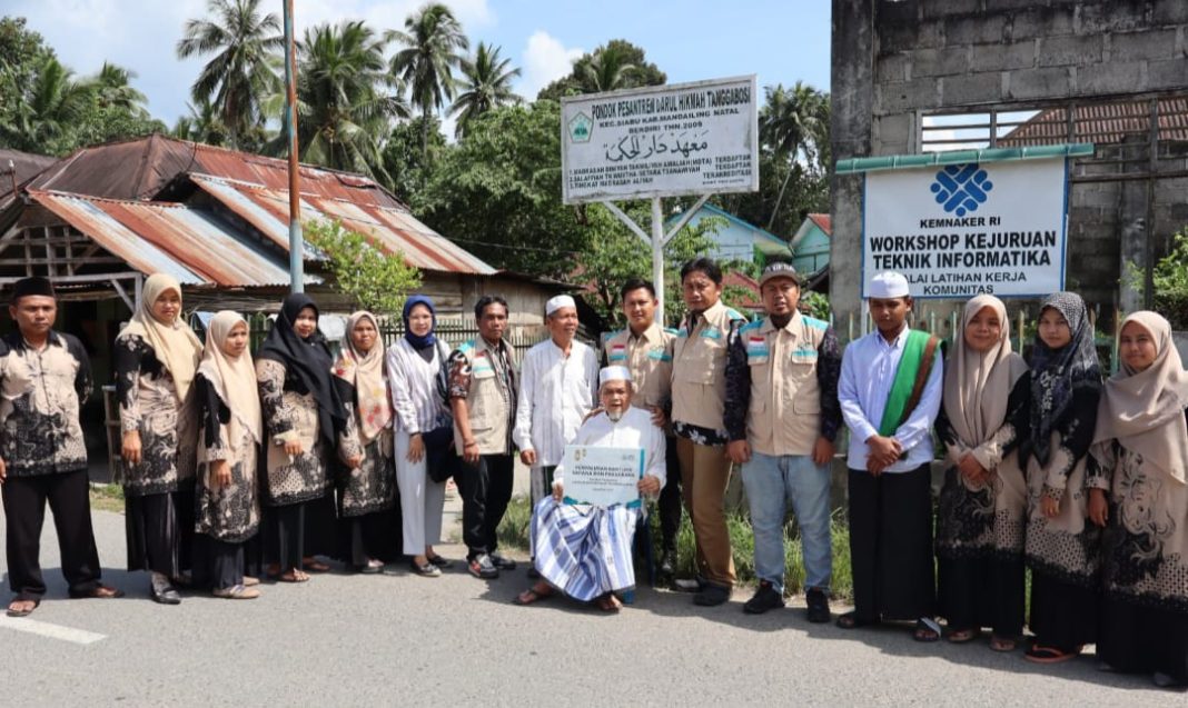 PLN UP3 Padangsidimpuan melalui Yayasan Baitul Maal (YBM) PLN menyerahkan bantuan kepada Pondok Pesantren Salafiyah Darul Hikmah Mandailing Natal, Sumut dan foto bersama, Sabtu (28/9/2024). (Dok/PLN)