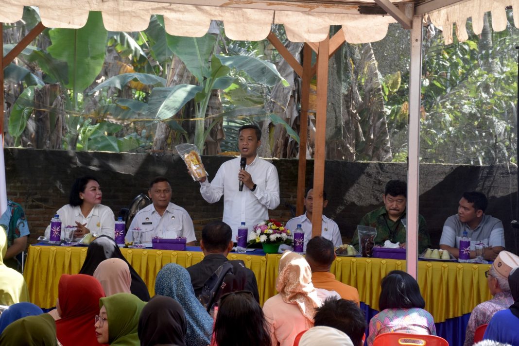 Pj Wali Kota Tebingtinggi Dr Moettaqien Hasrimi menunjukkan kerupuk pisang hasil olahan masyarakat di Rapat Pos Simpul Koordinasi Tingkat Kota Tebingtinggi Tahun 2024 di Jalan Danau Maninjau, Kel Padang Merbau, Kec Padang Hulu, Rabu (2/10/2024).