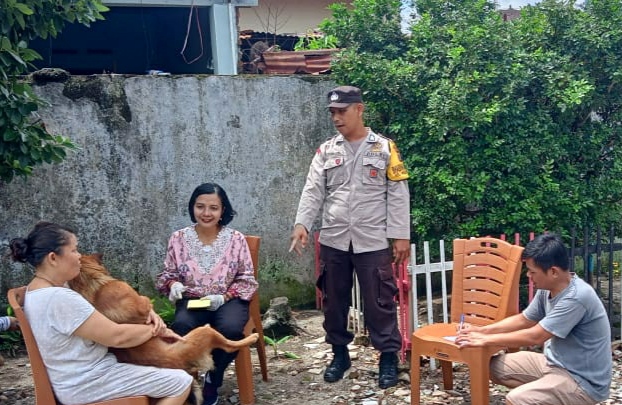 Bhabinkamtibmas Kelurahan Kebun Sayur saat melakukan pendampingan vaksinasi rabies hewan peliharaan warga di Jalan Sawi, Kelurahan Kebun Sayur, Kecamatan Siantar Timur, Sabtu (5/10/2024). (Dok/Polres Pematangsiantar)