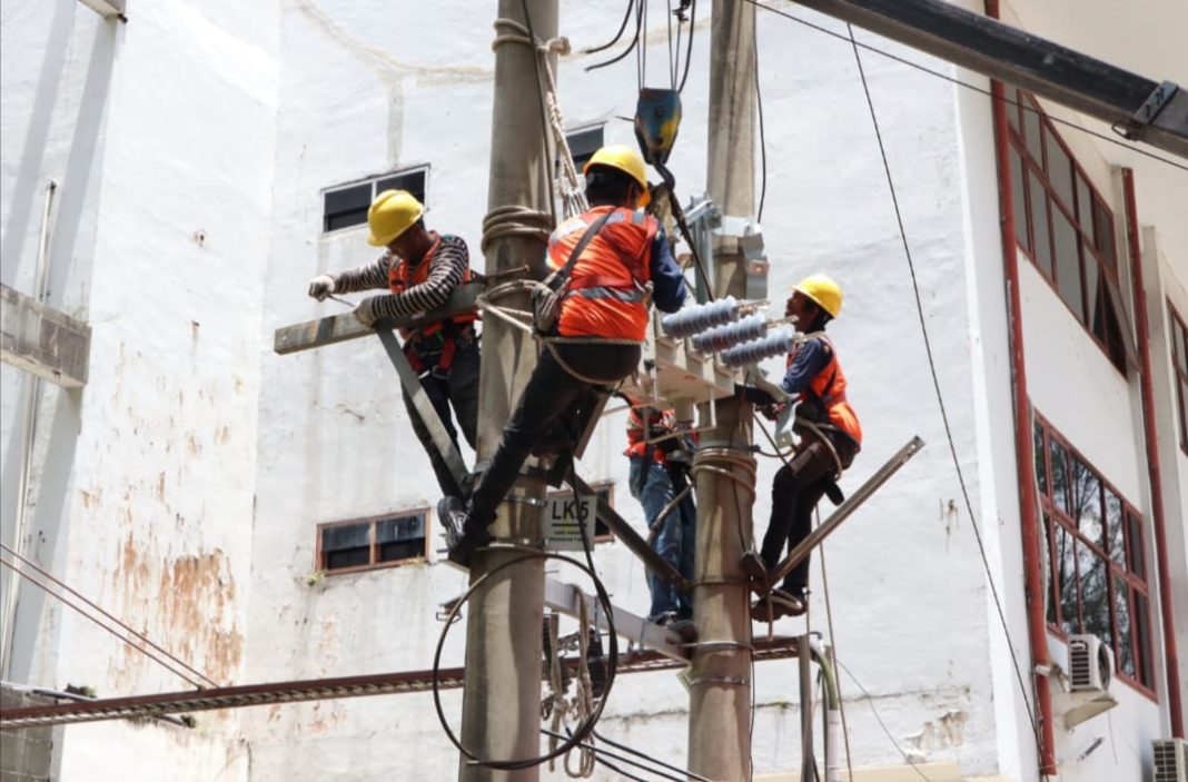 Petugas pelayanan teknik PLN UP3 Medan sedang melakukan pemasangan komponen jaringan listrik atas permohonan perubahan daya menggunakan layanan sameday service, Sabtu (5/10/2024). (Dok/PLN)