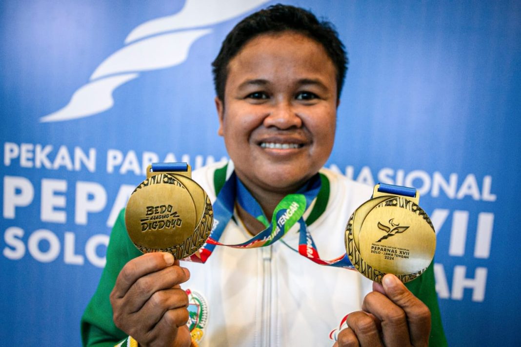 Lifter Sumut Sri Ramadani menunjukan kedua medali emasnya usai berhasil memecahkan rekor angkatan pada kelas 50,01 kg-55 kg putri kategori A para-angkat berat Peparnas XVII Solo 2024 di Hotel Sunan, Solo, Jawa Tengah, Selasa (8/10/2024). (Dok/PB Peparnas XVII)