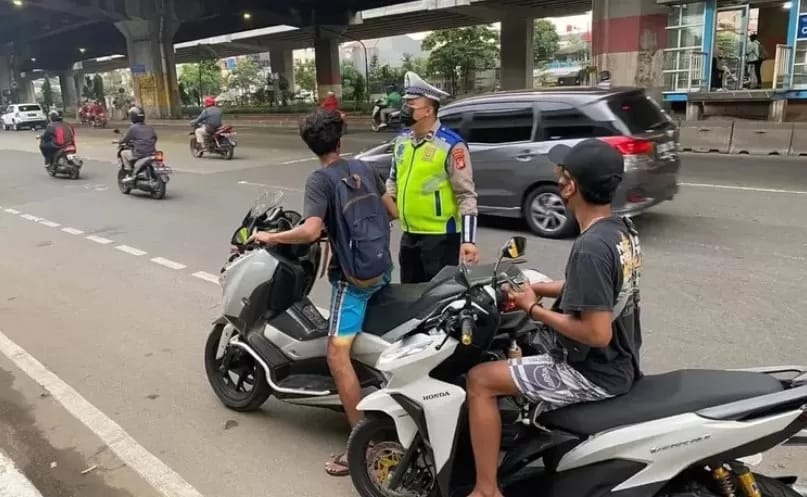 Polisi tengah menindak pengendara motor yang tidak memakai helm di Jakarta. (Dok/Humas Polri)