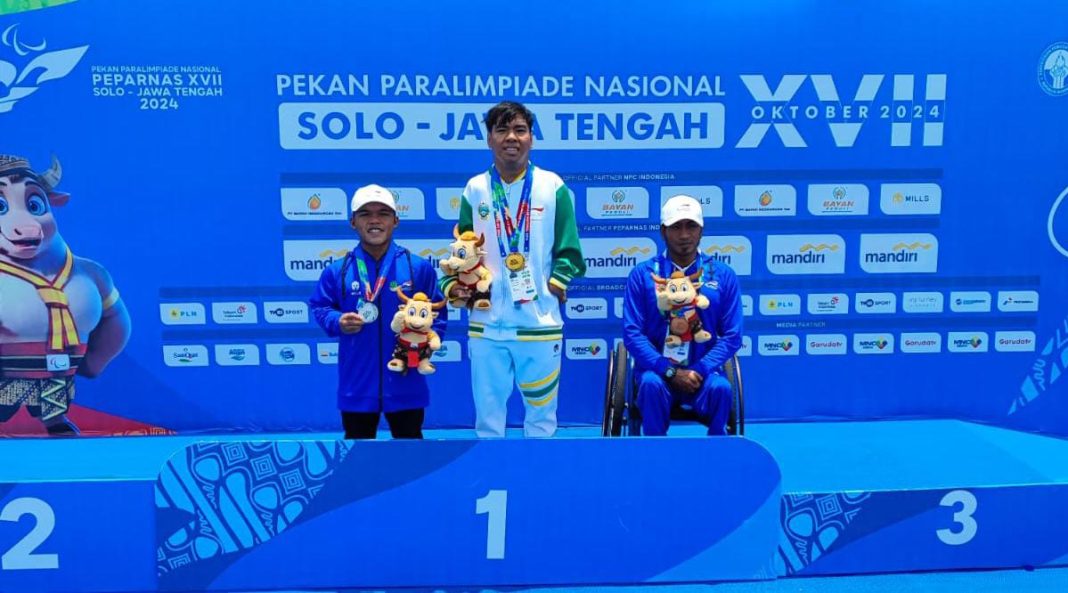 Atlet renang Sumut, Fadli Ramadhan berada di podium teratas Peparnas 2024 di kolam renang Intan Pari, Kabupaten Karanganyar, Sabtu (12/10/2024). Raihan emas itu turut mengamankan Sumut berada di posisi lima besar klasemen akhir. (Dok/NPC)