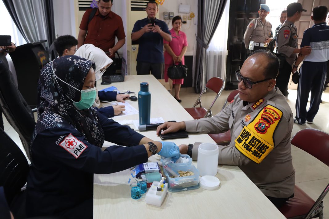 Kapolrestabes Medan Kombes Pol Gidion Arif Setyawan mengecek tensi sebelum mendonorkan darahnya di Aula Patriatama Polrestabes, Selasa (29/10/2024). (Dok/Polrestabes)