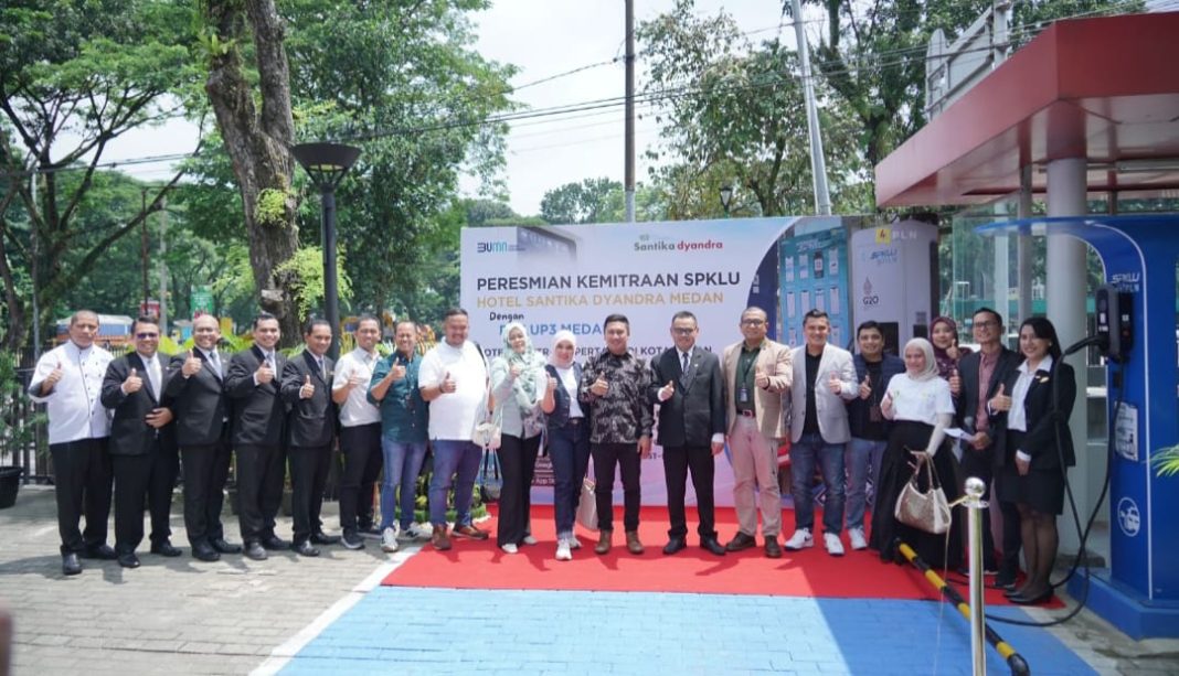 Manajemen PLN dan Manajemen Hotel Santika Dyandra Medan foto bersama di SPKLU. (Dok/PLN)