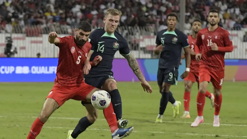 Bek Timnas Bahrain, Hamad Al-Shamsan, berebut bola dengan gelandang Timnas Australia, Riley McGree, dalam laga Kualifikasi Piala Dunia 2026 zona Asia di Bahrain National Stadium, Riffa, Rabu (20/11/2024) dini hari WIB.