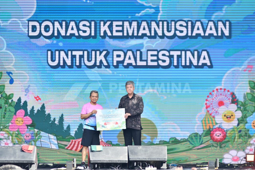 Wakil Direktur Pertamina Wiko Migantoro menyerahkan bantuan donasi kemanusian peduli Palestina saat acara Pertamina EcorunFest 2024 yang diselenggarakan di Gelora Bung Karno, Senayan, Jakarta pada Minggu (24/11/2024). (Dok/Pertamina)