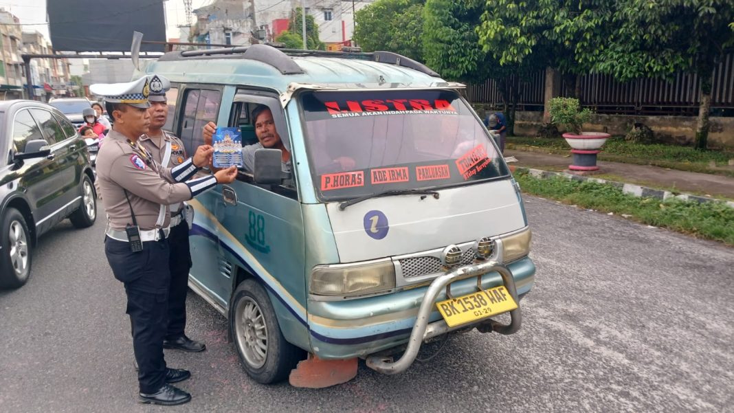 Petugas Sat Lantas Polres Pematangsiantar mengedukasi pengendara tertib berlalu lintas dan taat membayar pajak kendaraan saat penerangan keliling di jalanan Kota Pematangsiantar, Sabtu (2/11/2024). (Dok/Polres Pematangsiantar)